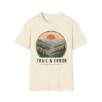 An off-white short-sleeve crewneck t-shirt featuring a circular graphic of a mountain landscape with a sunset and the text 'TRAIL & ERROR' and 'ESCAPE OFTEN'.