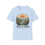 A light blue short-sleeve crewneck t-shirt featuring a circular graphic of a mountain landscape with a sunset and the text 'TRAIL & ERROR' and 'ESCAPE OFTEN' printed below it.